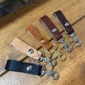 5 abe keychains laid out on wood bench