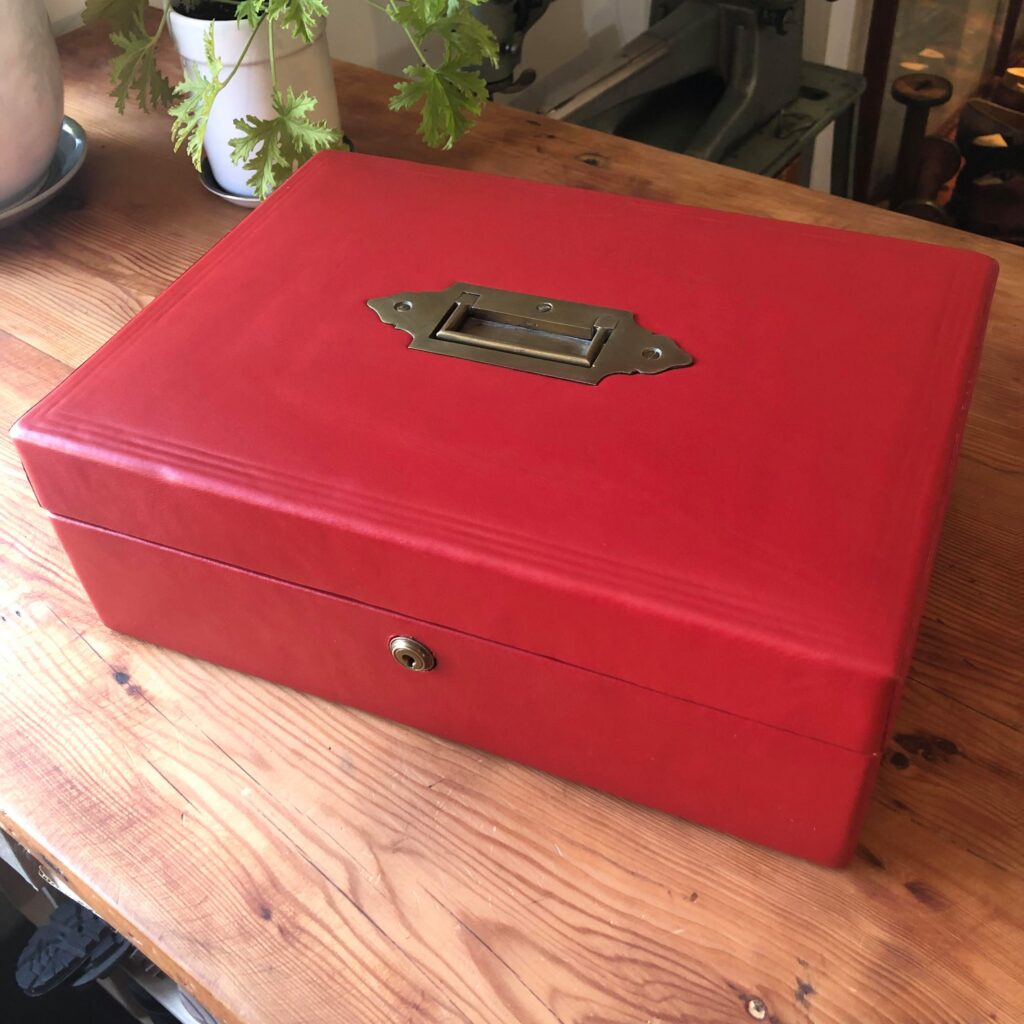 A leather box, upholstery in red