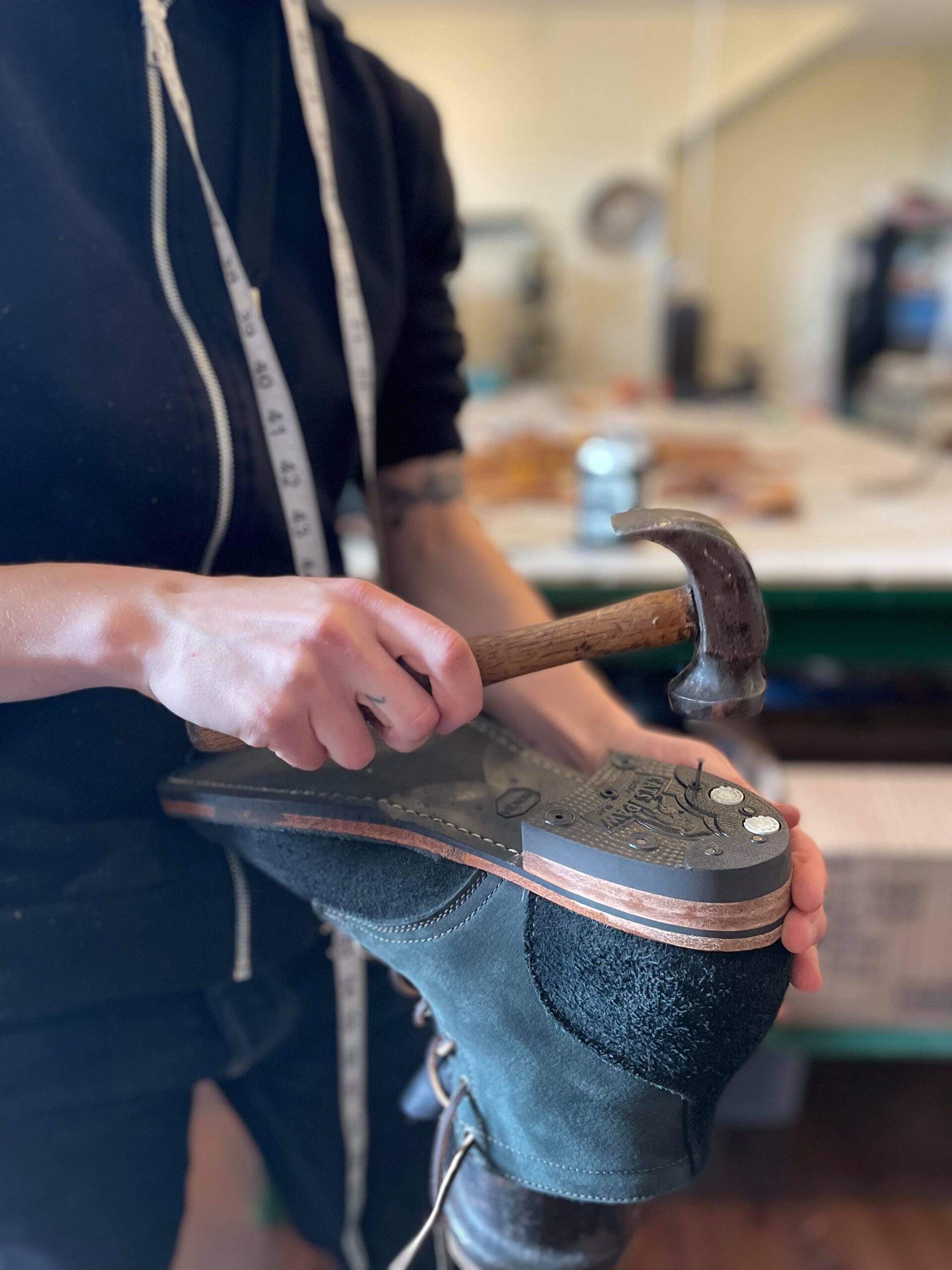 Ariss performing some shoe repairs on a boot heel, by nails