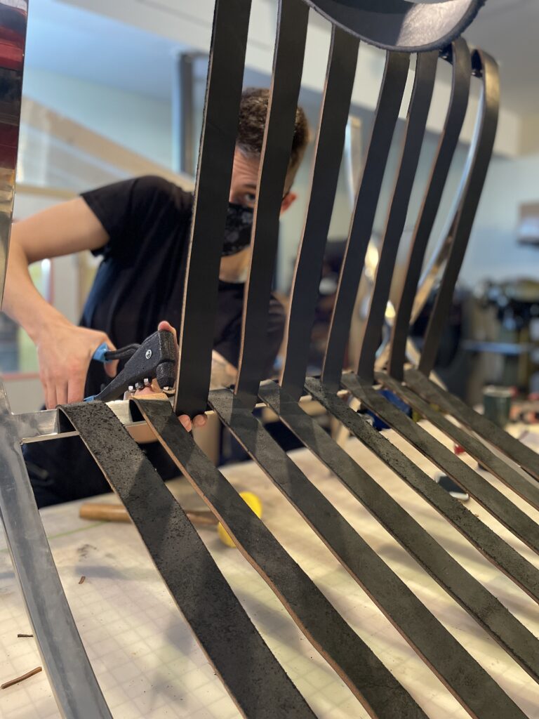 Ariss doing upholstery work on a Barcelona chair