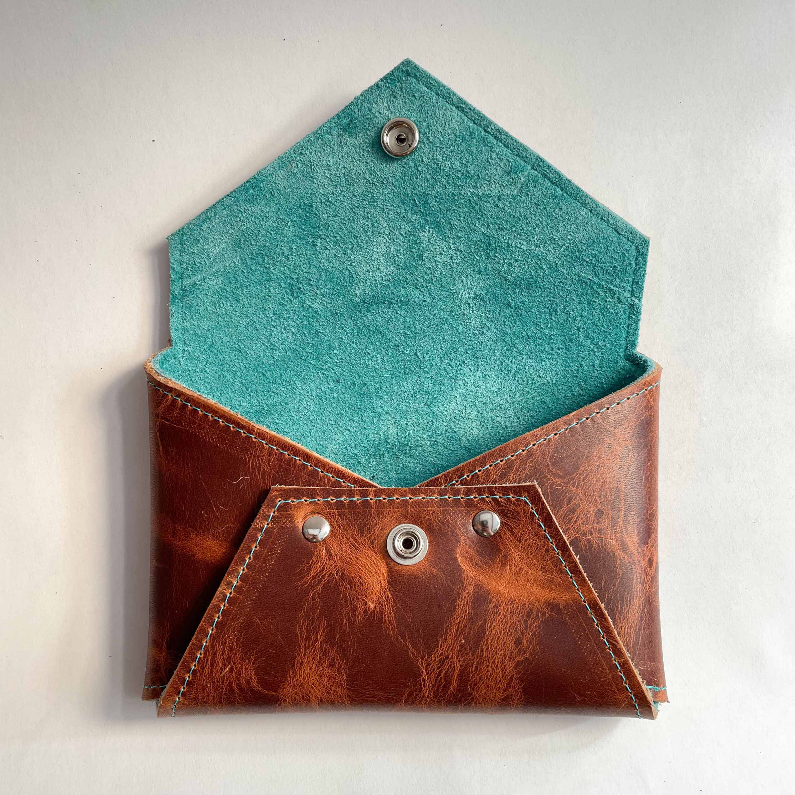 Open leather envelope clutch with teal lining