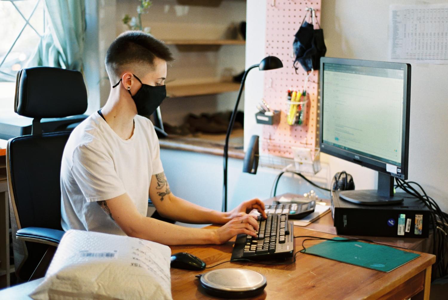 Ariss is sitting at th work computer and typing