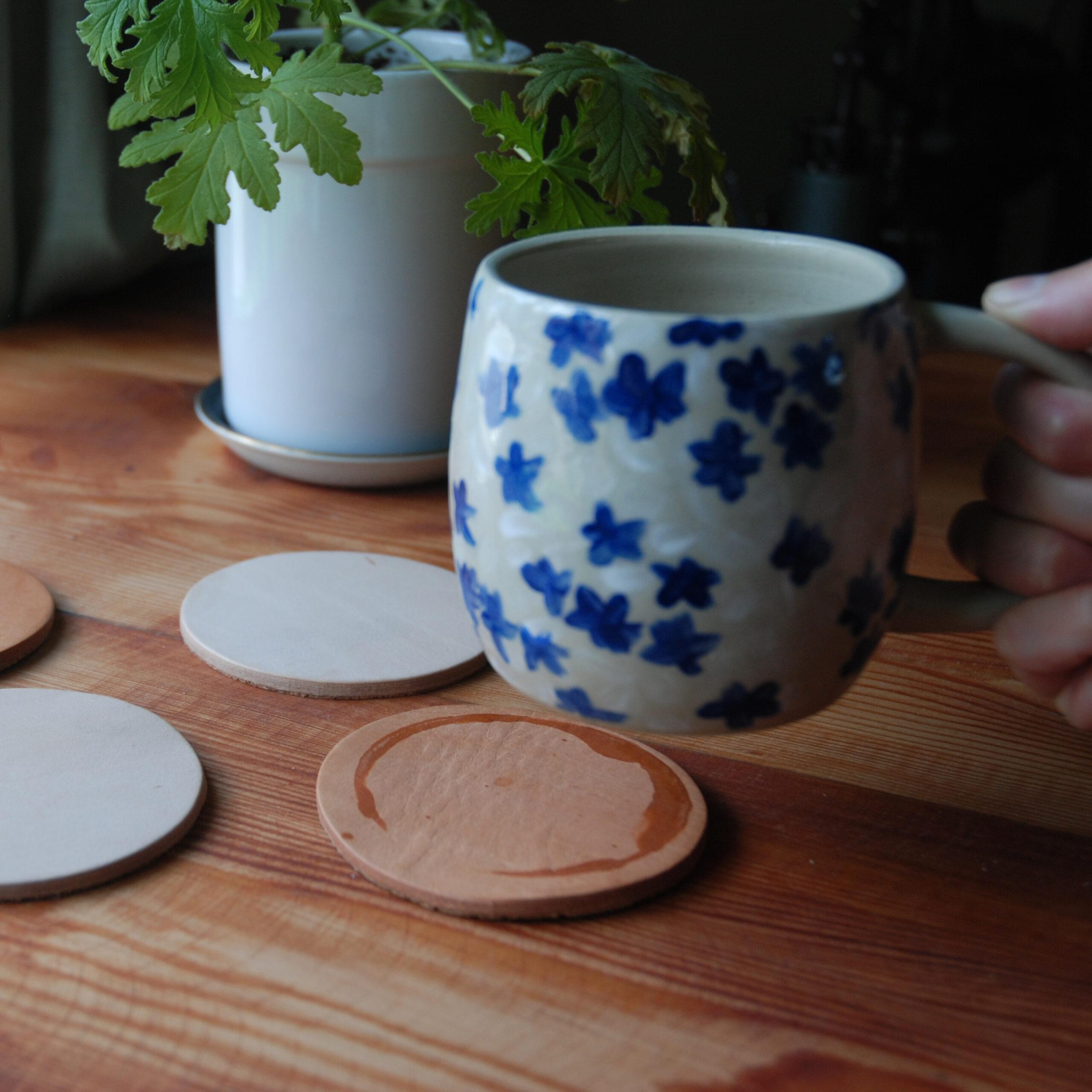 A mug in front of a leather coaster